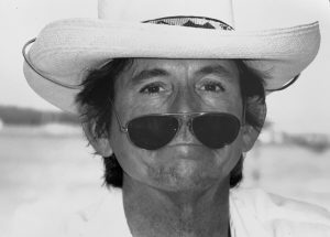 A man wearing sunglasses and a cowboy hat.