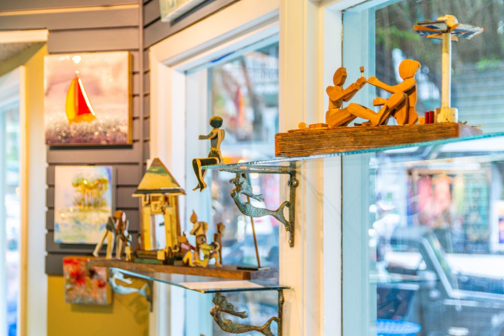 A window display of wooden figurines and other items.