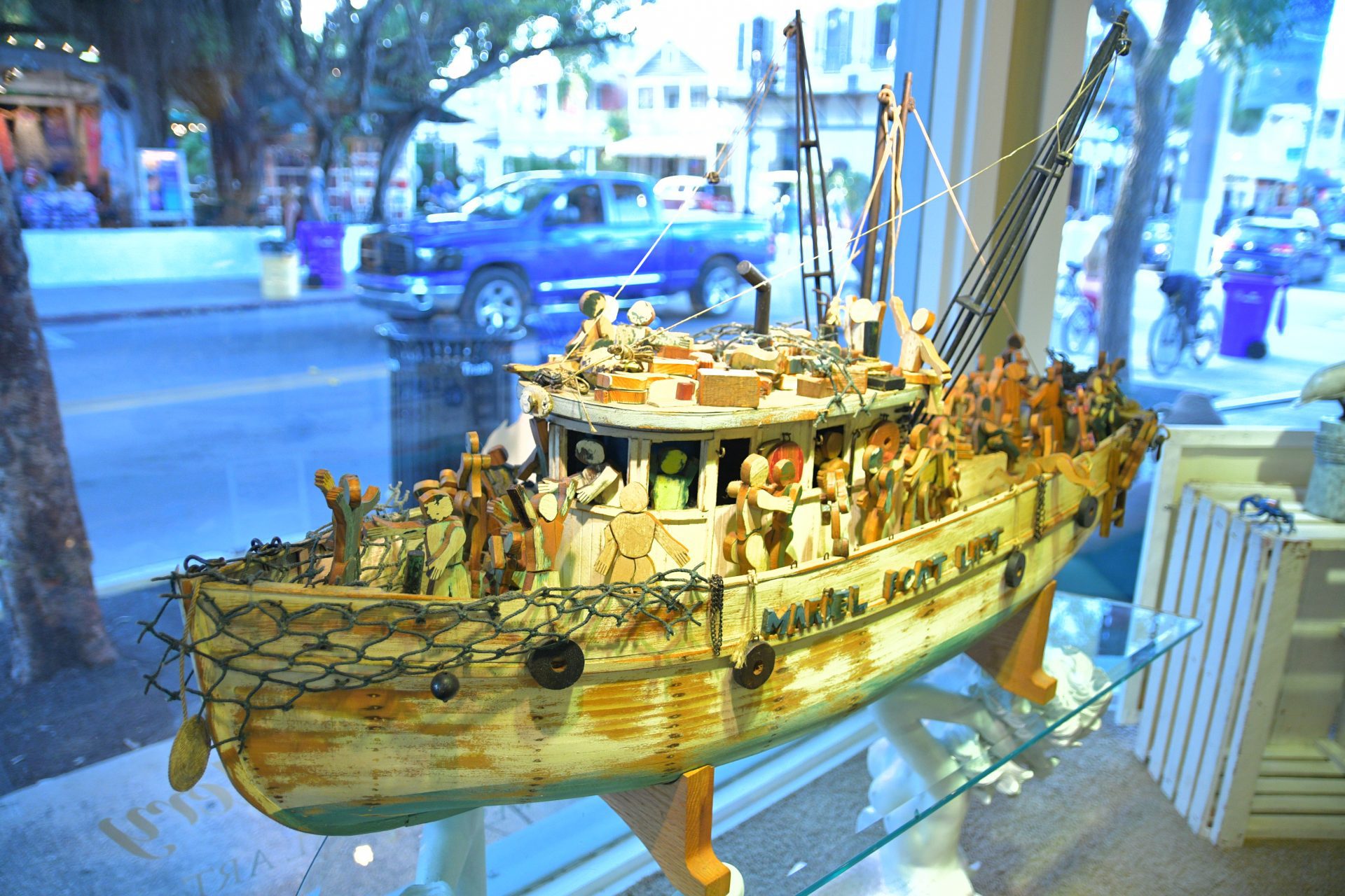 A wooden boat with people on it in front of a window.